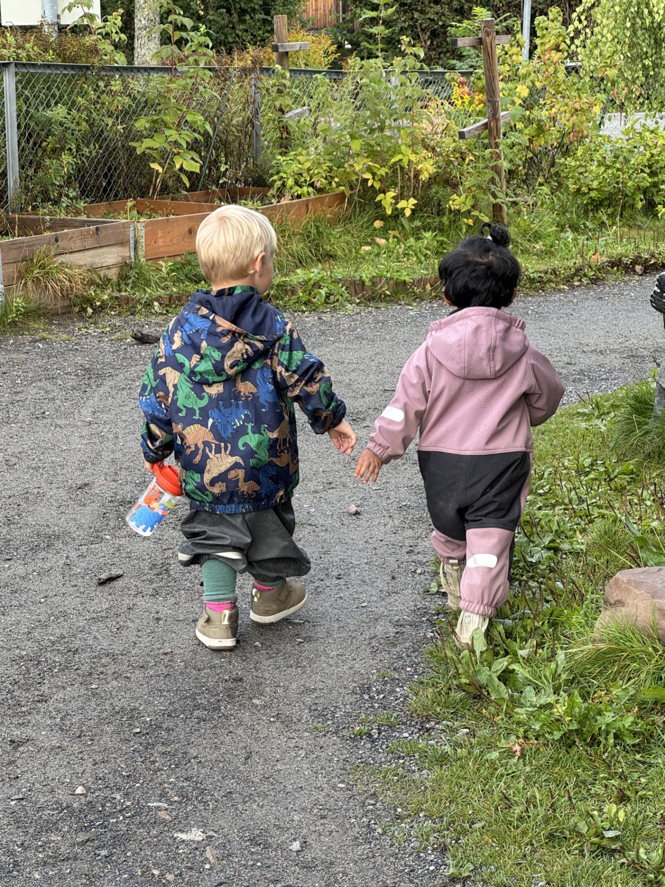 To barn holder hender på tur i barnehagen